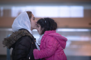 Photo: A mother kisses her daughter on the forehead.