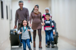 A Middle-eastern father, mother, brother and two sisters have just arrived to their new apartment building.